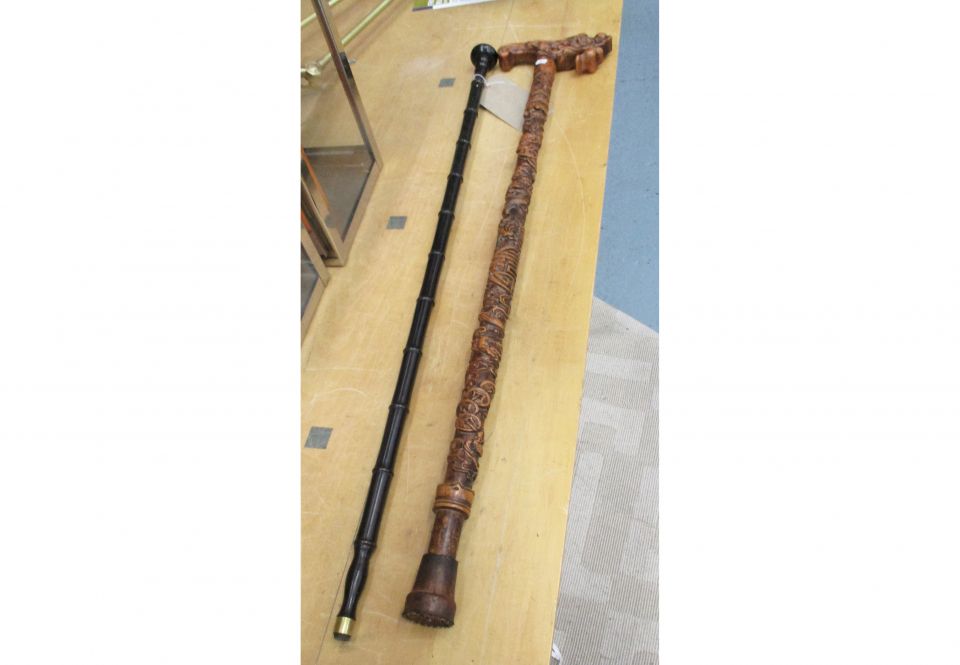 WALKING STICKS, two, one heavily carved, the other ebonised bamboo