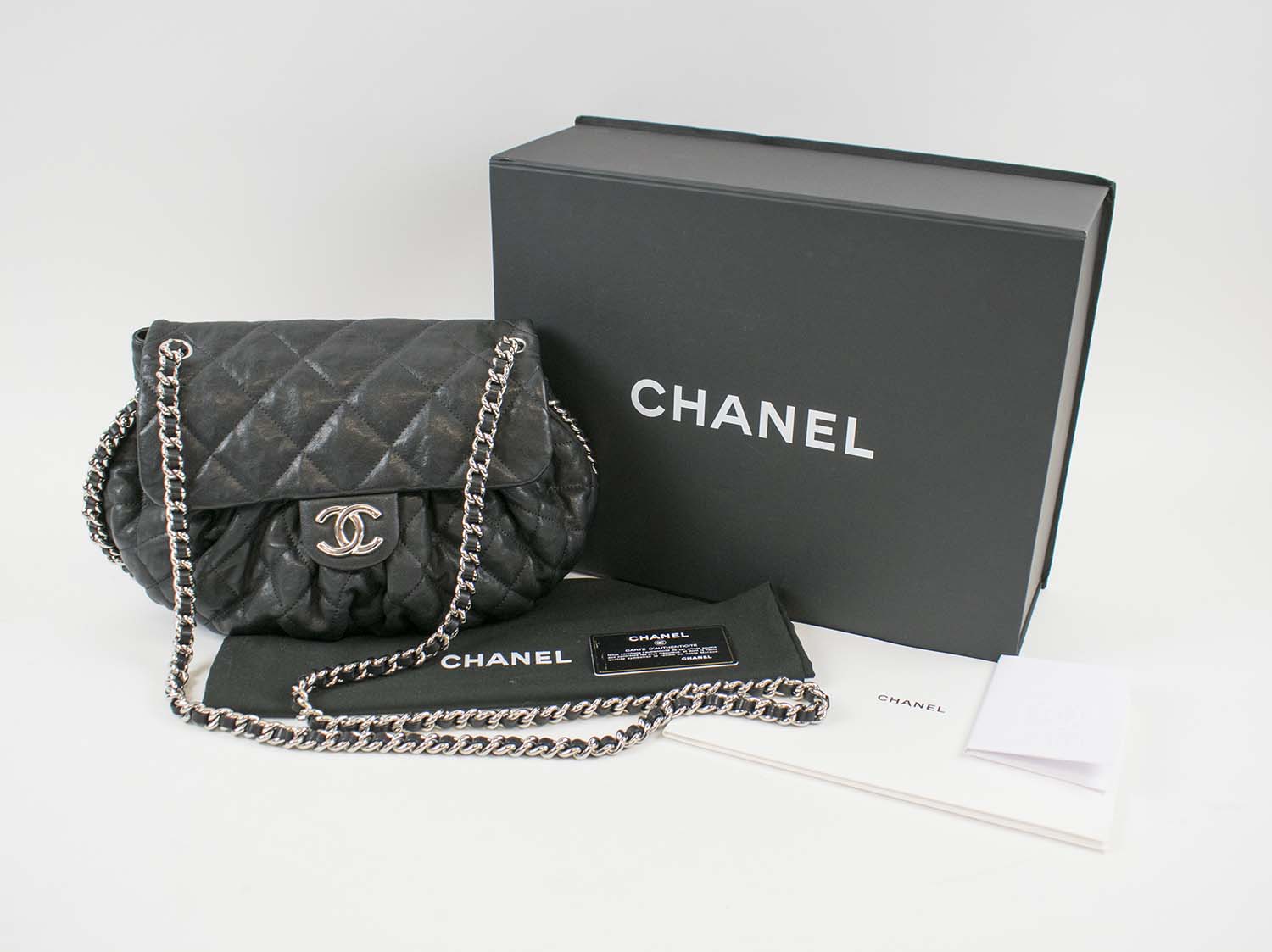 CHANEL CHAIN AROUND MESSENGER BAG, black quilted leather with silver tone  hardware, chain and leather strap and around the edges of the bag, cream  fabric lining, authenticity card, original box, 30cm x