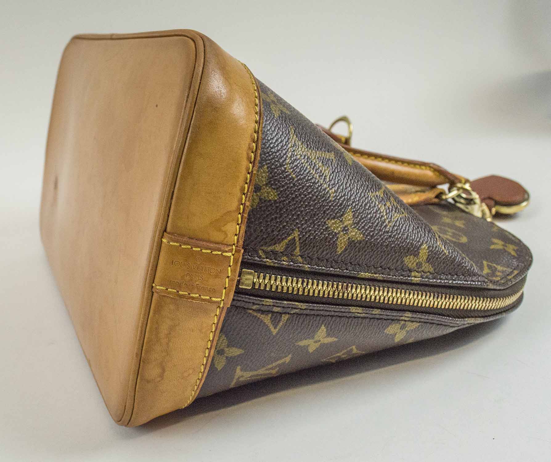 LOUIS VUITTON ALMA BAG, monogram canvas with two top vacchetta leather  handles and trims, double zip with padlock closure and two keys, key ring  charm, brass tone hardware, fabric lining with dust